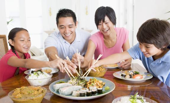 Family sharing a meal together with a variety of dishes, highlighting balanced eating and foods that can contribute to fibre intake